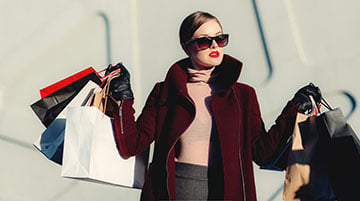 Retail presenter holding shopping bags for a product broadcast